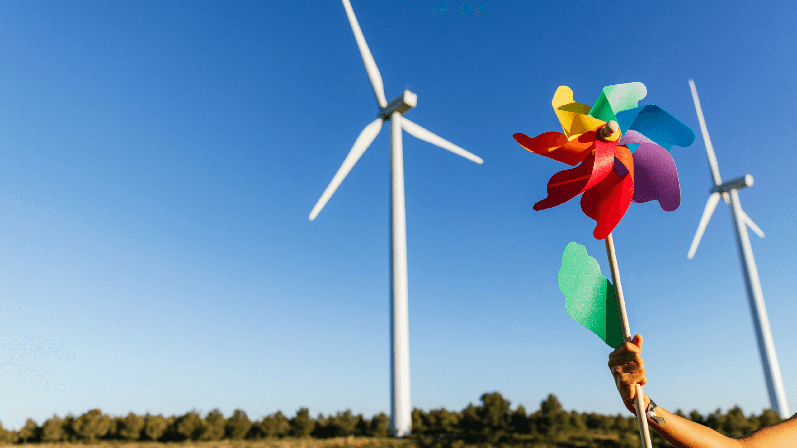 Why are some turbines spinning but not others - Person with pinwheel under a bright blue sky